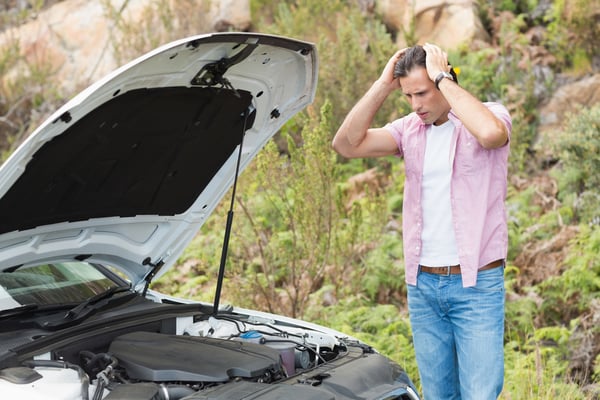 Stressed man looking at engine of his car